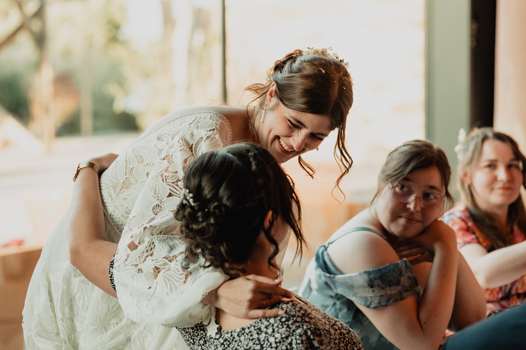 Mariée partageant un câlin joyeux avec ses amies au Domaine Imodis à Saessolsheim