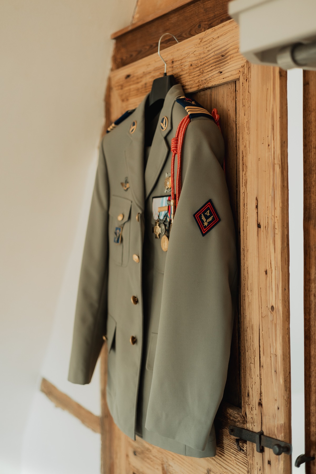 Veste d'uniforme militaire du marié suspendue, préparatifs au Domaine Imodis