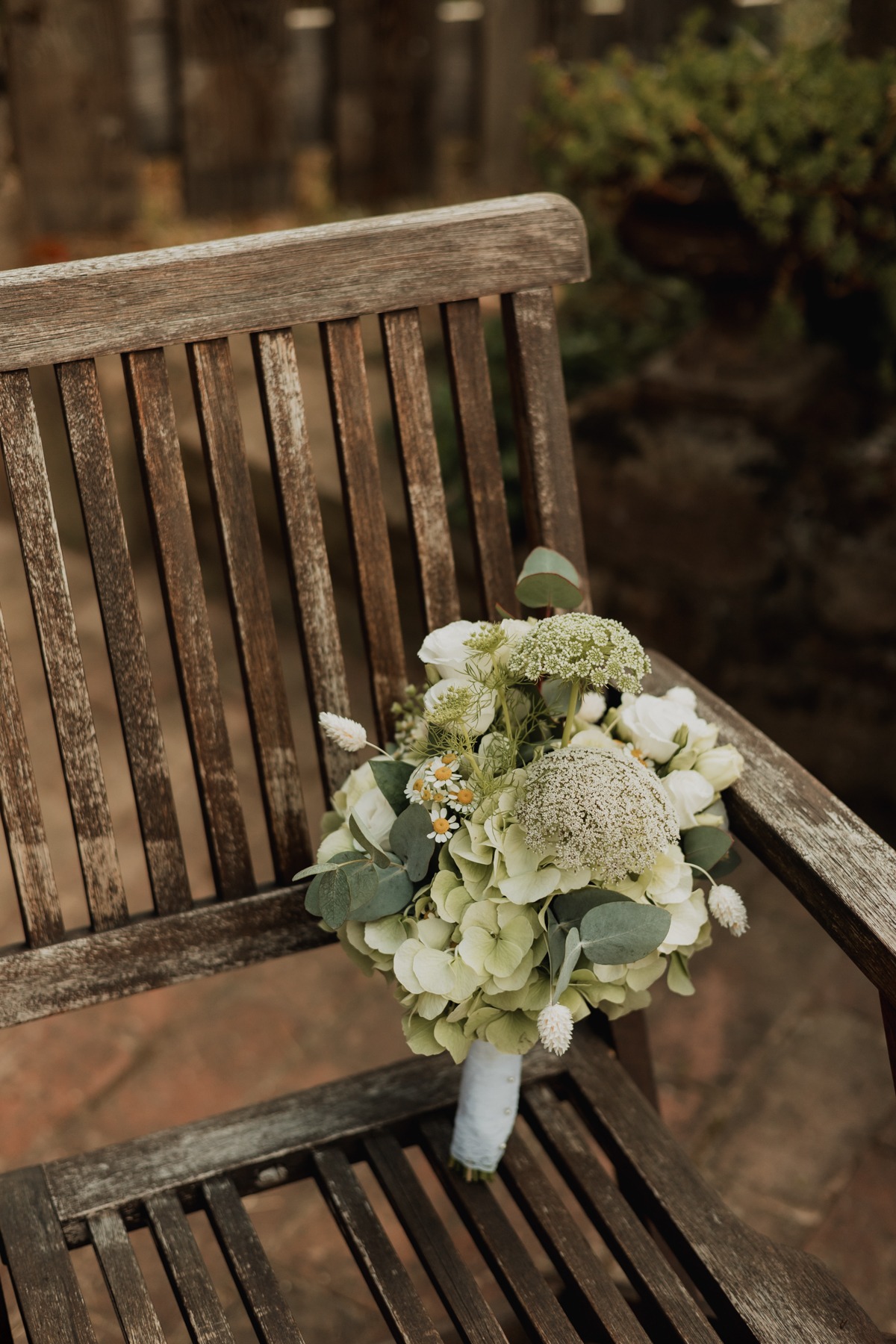 Bouquet de la mariée posé sur un banc en bois au Domaine Imodis à Saessolsheim