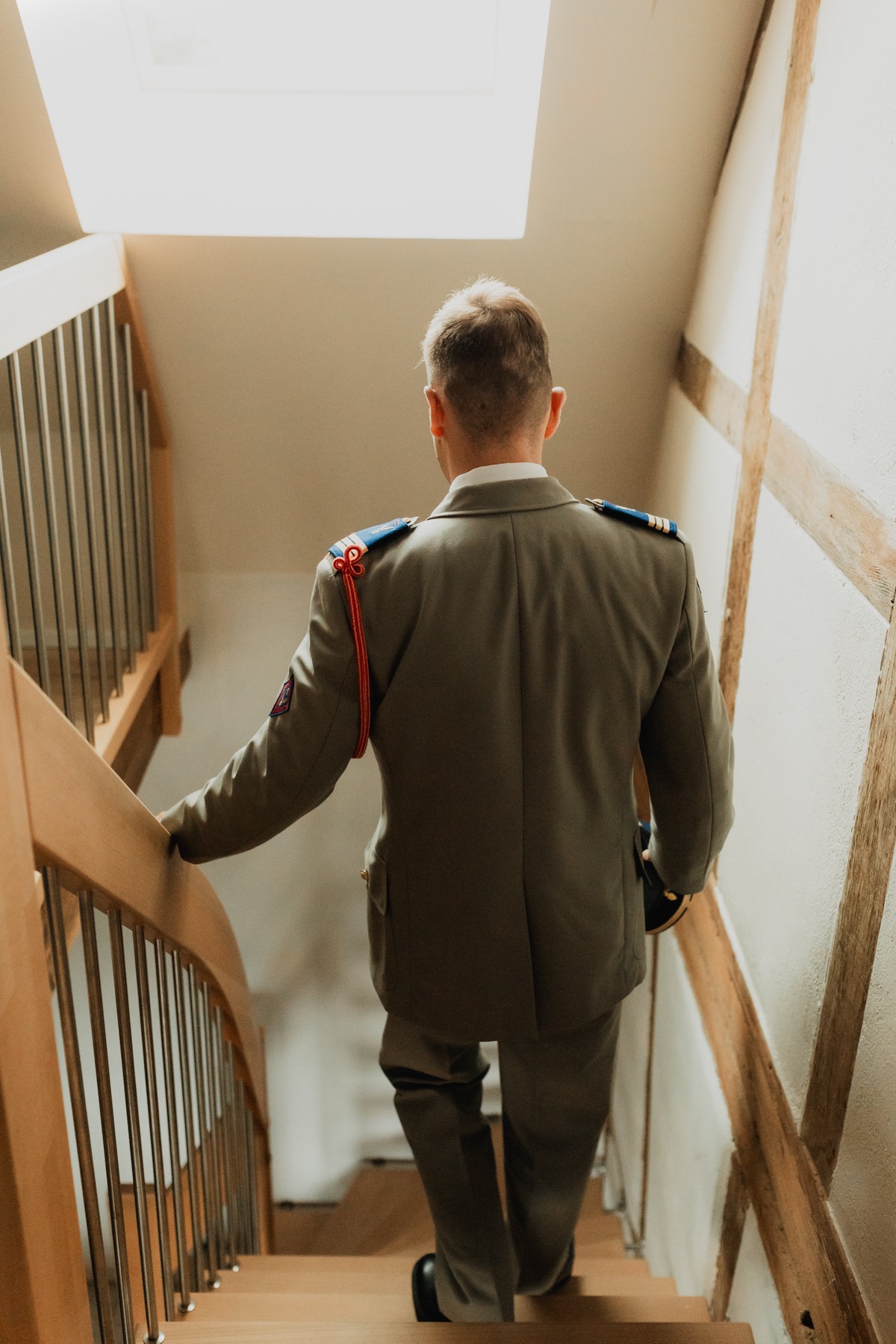 Marié en tenue militaire descendant l'escalier avant la cérémonie au Domaine Imodis à Saessolsheim