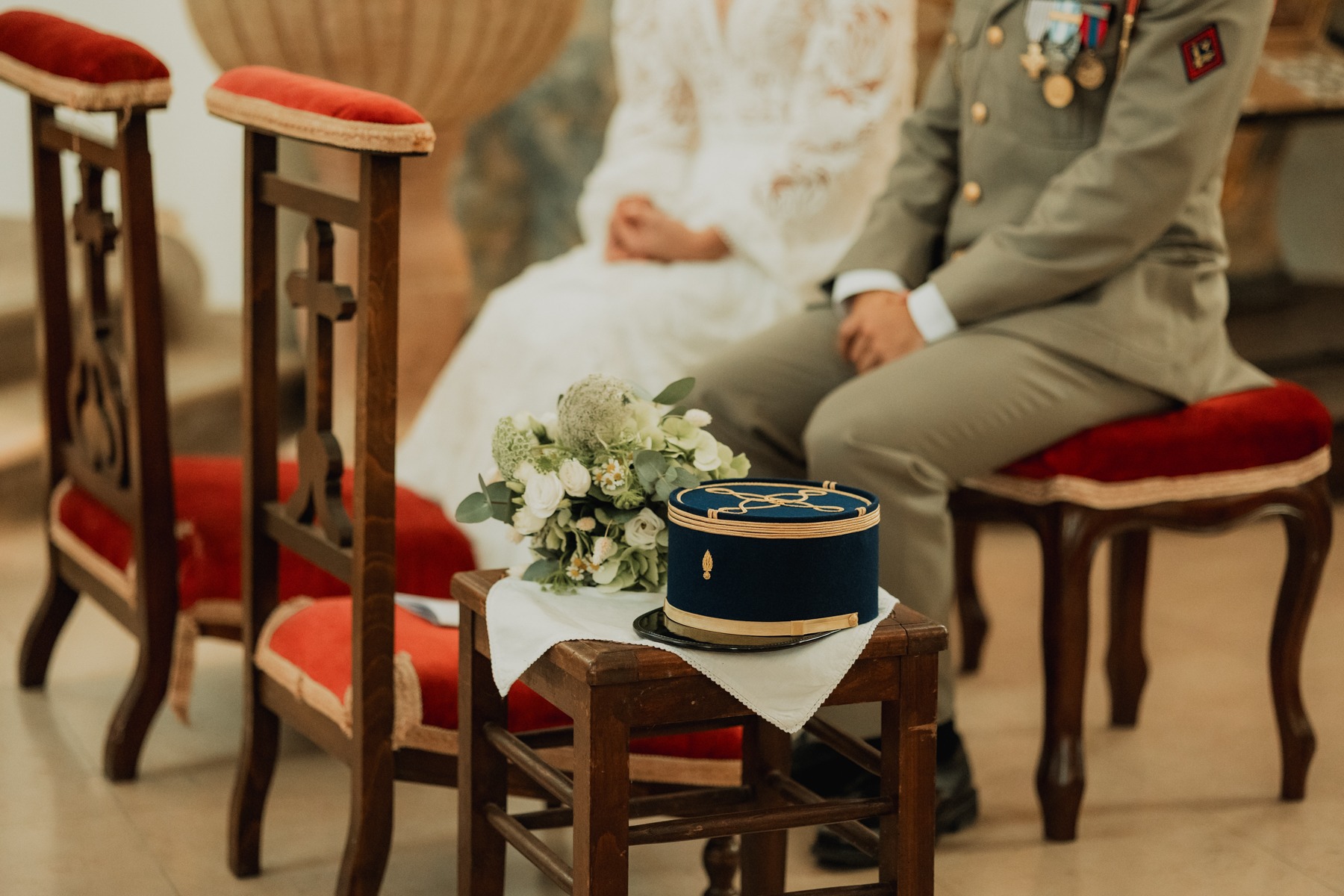 Mariés assis au prie-Dieu avec bouquet et casquette militaire à l'église de Saessolsheim en Alsace