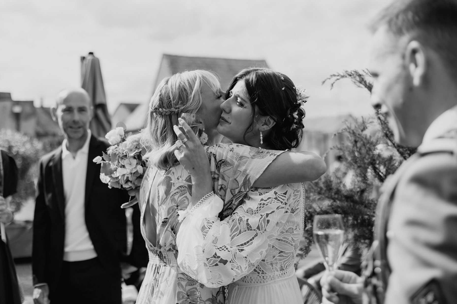 Mariée partageant une accolade émue avec ses proches lors de son mariage au Domaine Imodis à Saessolsheim