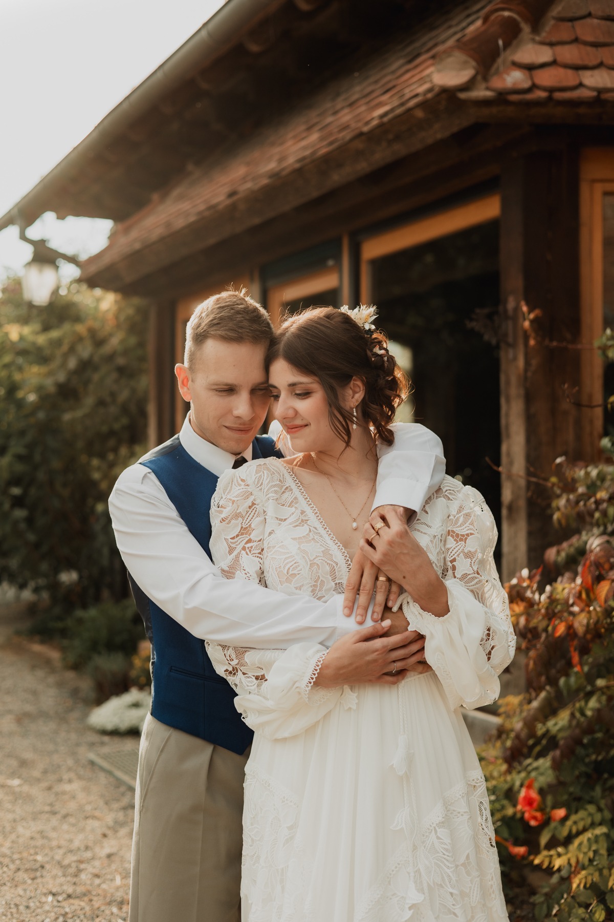 Portrait romantique des mariés enlacés devant le bâtiment du Domaine Imodis à Saessolsheim