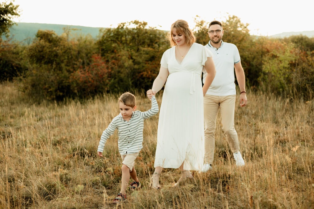 Séance maternité en famille en extérieur : promenade entre parents et grand frère sur les hauteurs du Bollenberg