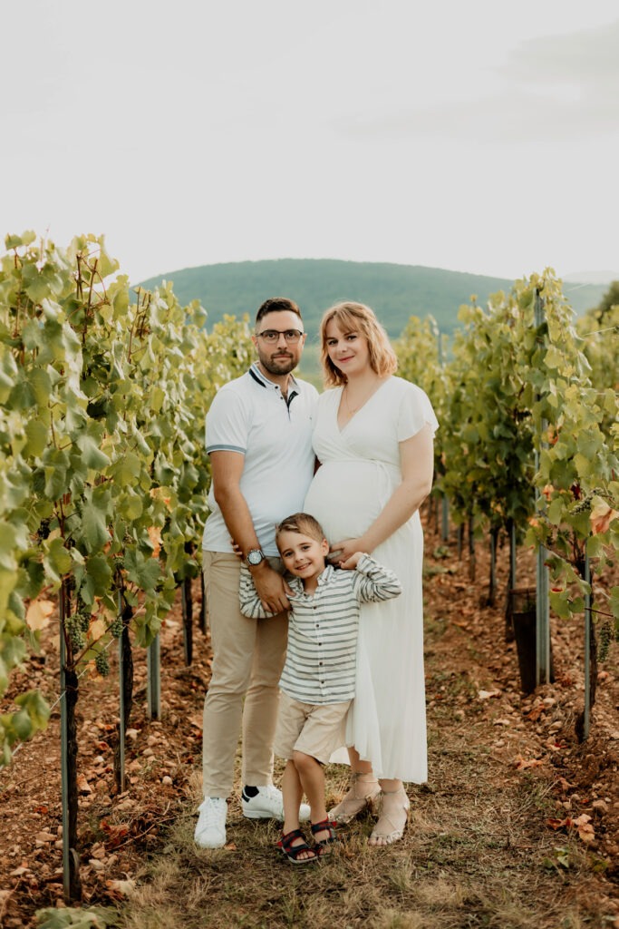 Séance maternité en extérieur dans les vignes d'Alsace : portrait de famille au Bollenberg