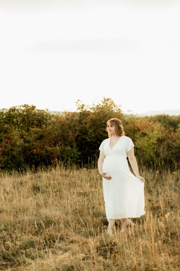 Photographe grossesse en Alsace : séance maternité en extérieur, future maman dans les herbes hautes du Bollenberg